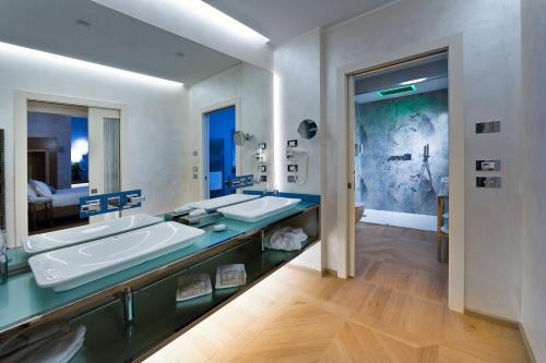 a bathroom with two sinks and a large mirror at Vip's Motel Luxury Accommodation & Spa in Lonato del Garda