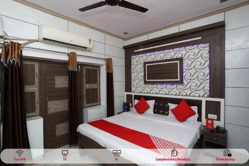 sypialnia z łóżkiem i telewizorem na ścianie w obiekcie OYO Hotel Vanshika w mieście Agra