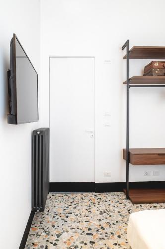 a living room with a tv and a radiator and a floor at Ortigia's gate in Siracusa