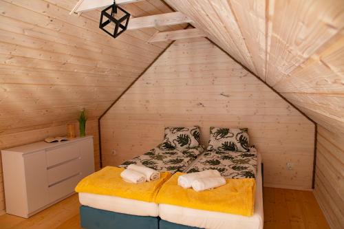 ein Schlafzimmer mit einem Bett im Dachgeschoss in der Unterkunft Domki u Łysego in Dębki