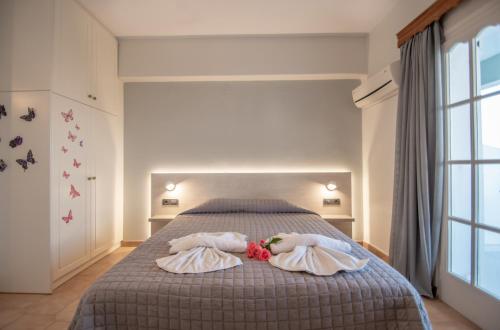 two people laying on a bed in a bedroom at Baywatch Apartments on the Beach by "elite" in Amoudi