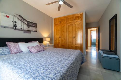 a bedroom with a bed and a ceiling fan at Bonita casa en Granada+PARKING EN EL CENTRO+WIFI in Ambroz