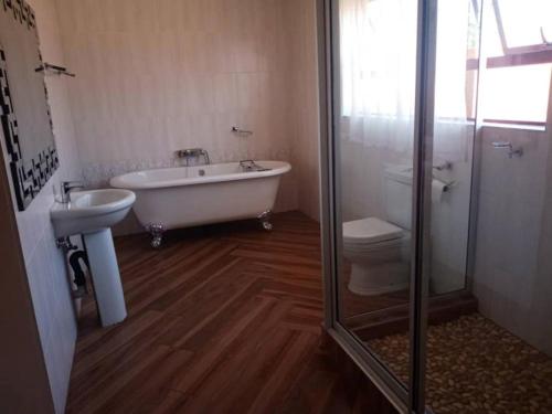 a bathroom with a tub and a sink and a toilet at Beautiful guesthouse with pool and solar - 2057 in Victoria Falls