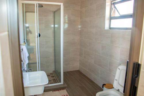 a bathroom with a shower and a sink and a toilet at Standard room in Morningside guesthouse - 2090 in Bulawayo