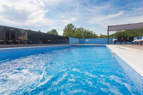 ein Pool mit blauem Wasser in einem Gebäude in der Unterkunft Villa Tomic in Trnbusi
