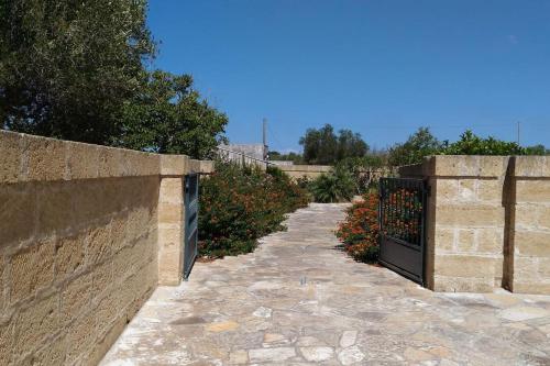 un camino de piedra con una puerta y una valla en Casa vacanze Maria su Castro Marina, Lecce - Salento en Vignacastrisi