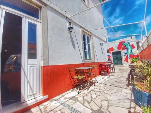 a group of chairs and tables outside of a building at Meraki Hostel in Sintra