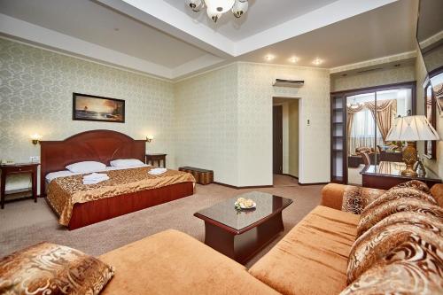 a hotel room with a bed and a couch at Royal Street Hotel in Odesa