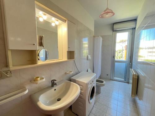bagno con lavandino, servizi igienici e specchio di Venere Apartament a Tirrenia