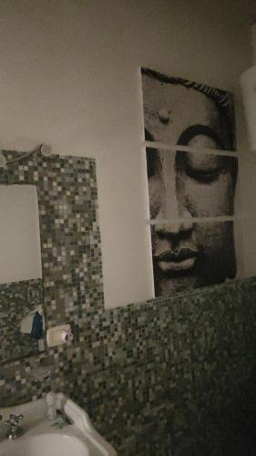 een badkamer met een foto van een gezicht op de muur bij Palazzo Gancia holiday homes in Siracusa
