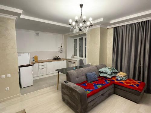 ein Wohnzimmer mit einem Sofa und einer Küche in der Unterkunft Апартаменты в районе Болашак in Aqtöbe