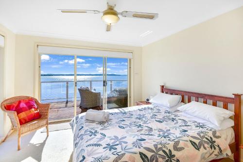 1 dormitorio con cama y vistas al océano en Bluewater at Mannering Park, en Mannering Park