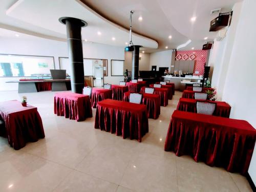una habitación con mesas rojas y sillas en un restaurante en OS Hotel Tanjung Uncang, en Sagulung
