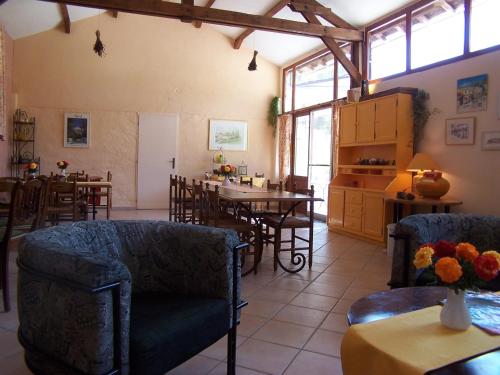 un salon avec des chaises et une table et une cuisine dans l'établissement Au Moulin d'Antan- Gîtes dans la Drôme, à Beaumont-en-Diois