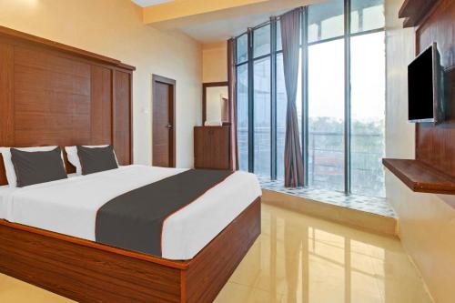 Hotel Aqua Villa Near Netaji Subhash Chandra Bose في Gauripur: غرفة نوم بسرير كبير ونافذة كبيرة