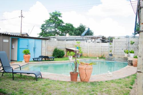uma piscina num quintal com um banco e uma cadeira em Neat one bedroom in Morningside guesthouse - 2091 em Bulawayo