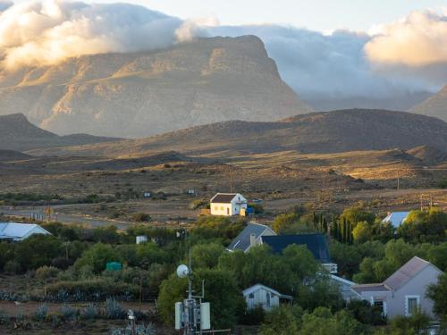 a mountain in the distance with a town and houses at Klaarstroom Hotel in Klaarstroom