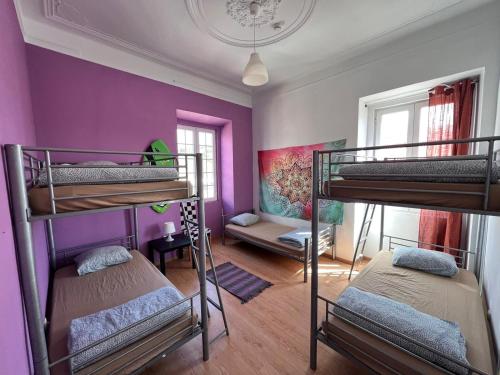 - 2 lits superposés dans un dortoir aux murs violets dans l'établissement Meraki Hostel, à Sintra