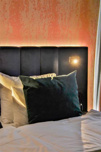 a bed with a black headboard and white pillows at ProfilHotels Halmstad Plaza in Halmstad