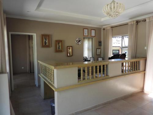 a living room with a staircase and a chandelier at 2 bedroomed apartment with en-suite and kitchenette - 2071 in Harare