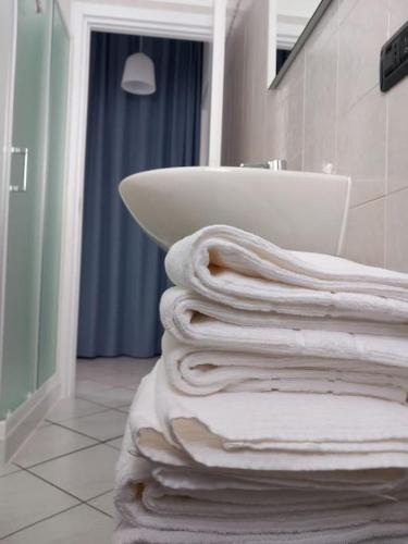 uma pilha de toalhas numa casa de banho com lavatório em La Casa al Lago, Reno di Leggiuno em Reno Di Leggiuno