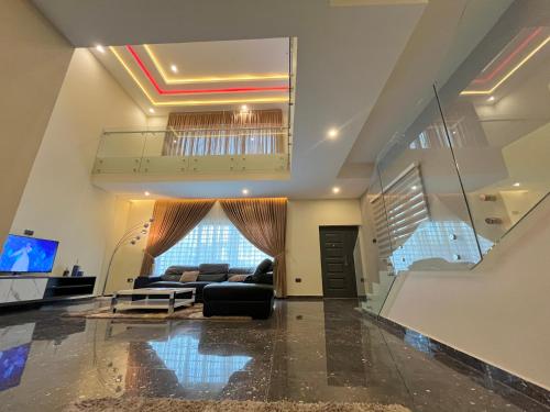a living room with a couch and a staircase at Sydney’s villa in Accra