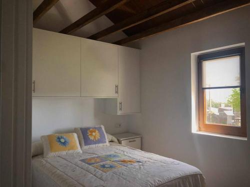 a small bedroom with a bed and a window at A CASA DO ACIVRO in Outes