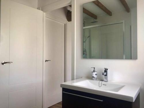 a bathroom with a white sink and a mirror at A CASA DO ACIVRO in Outes