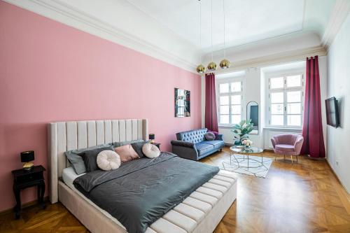 1 dormitorio con cama y pared de color rosa en New Stylish 3 Suites Bedrooms Apt in Mala Strana - N2nd en Praga