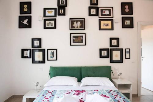 een slaapkamer met een groen bed en ingelijste foto's aan de muur bij La Casa dell’Artista in La Spezia
