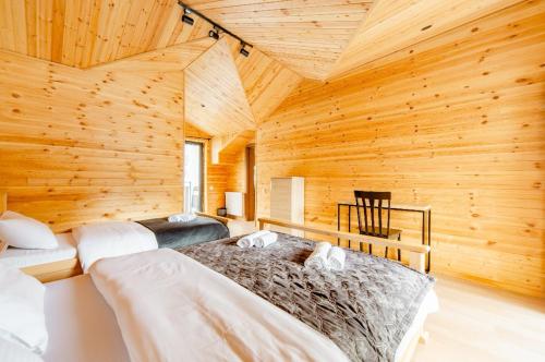 a bedroom with two beds in a wooden room at Aronia Kazbegi in Stepantsminda
