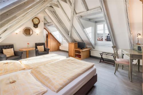 a bedroom with two beds and a desk and a clock at Hotel-Restaurant Hackteufel in Heidelberg