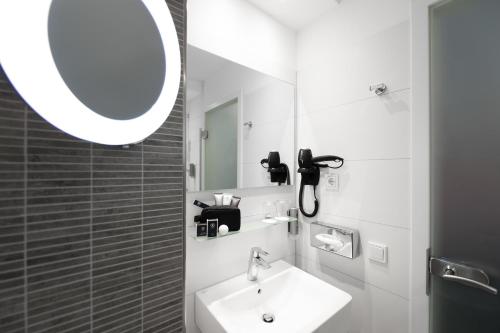 a bathroom with a sink and a mirror at Best Western Plus Parkhotel Velbert in Velbert