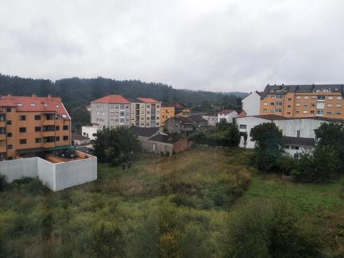 uma vista para uma cidade com edifícios e árvores em Los Coucheiros em Negreira