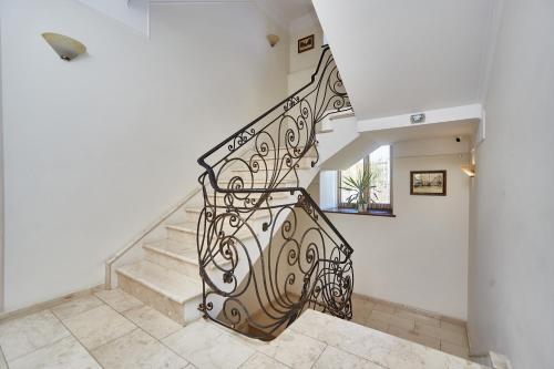a staircase with a wrought iron railing in a house at Royal Street Hotel in Odesa