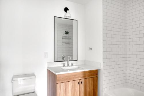 a bathroom with a sink and a mirror and a tub at Hoboken 1BR w Elevator Gym Terrace Courtyard NYC-790 in Hoboken