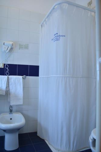 a bathroom with a white shower curtain and a toilet at eco Hotel Milano & BioRiso Restaurant in Milan