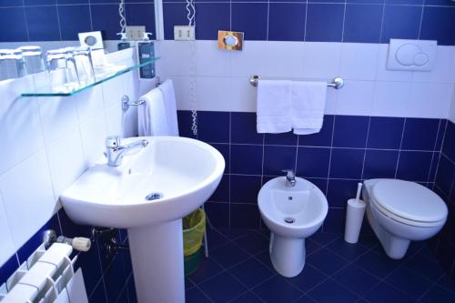 a blue and white bathroom with a sink and a toilet at eco Hotel Milano & BioRiso Restaurant in Milan
