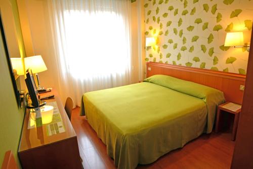 a bedroom with a green bed and a window at eco Hotel Milano & BioRiso Restaurant in Milan