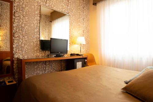 a hotel room with a bed and a television at eco Hotel Milano & BioRiso Restaurant in Milan