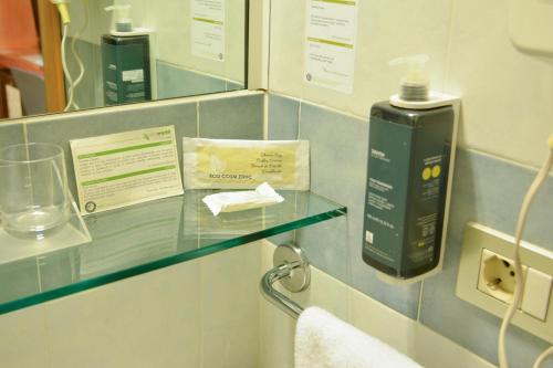 a bathroom with a glass shelf in a room at eco Hotel Milano & BioRiso Restaurant in Milan