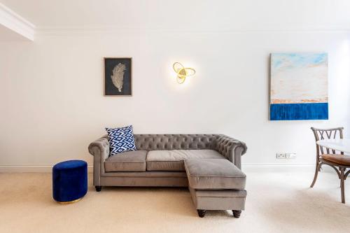 uma sala de estar com um sofá e uma cadeira em Fabulous Westminster Flat em Londres
