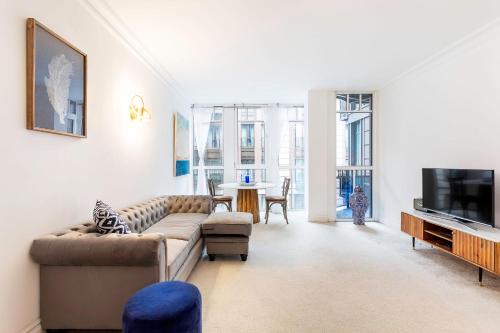 uma sala de estar com um sofá e uma televisão em Fabulous Westminster Flat em Londres