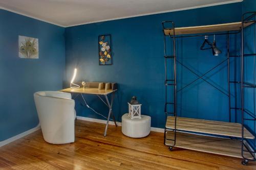 ein Badezimmer mit blauen Wänden, einer Badewanne und einem Regal in der Unterkunft Le Grand Fief - Appt pour 4 voyageurs in Bourg-Charente
