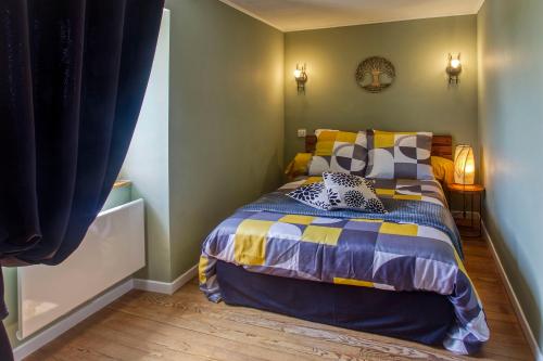 ein Schlafzimmer mit einem Bett mit bunten Decken und Kissen in der Unterkunft Le Grand Fief - Appt pour 4 voyageurs in Bourg-Charente