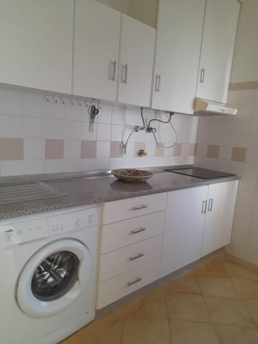 een keuken met een wasmachine en een wastafel bij Apartamento Maria in Lagos
