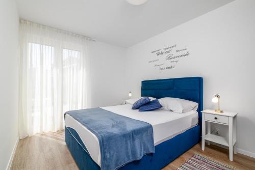 Schlafzimmer mit einem blauen und weißen Bett und einem Fenster in der Unterkunft Villa Ida in Rovinj