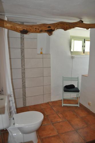 uma casa de banho com um WC e uma cadeira em La Estrellita em Iznájar