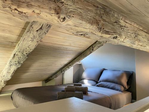 Cama en habitación con techo de madera en TOURinTURIN appartamento in Torino centro, en Turín