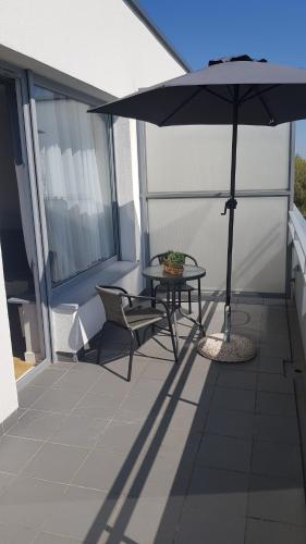 a patio with a table and an umbrella on a balcony at Posnania Comfort Apartment, free parking, self check-in 24h in Poznań